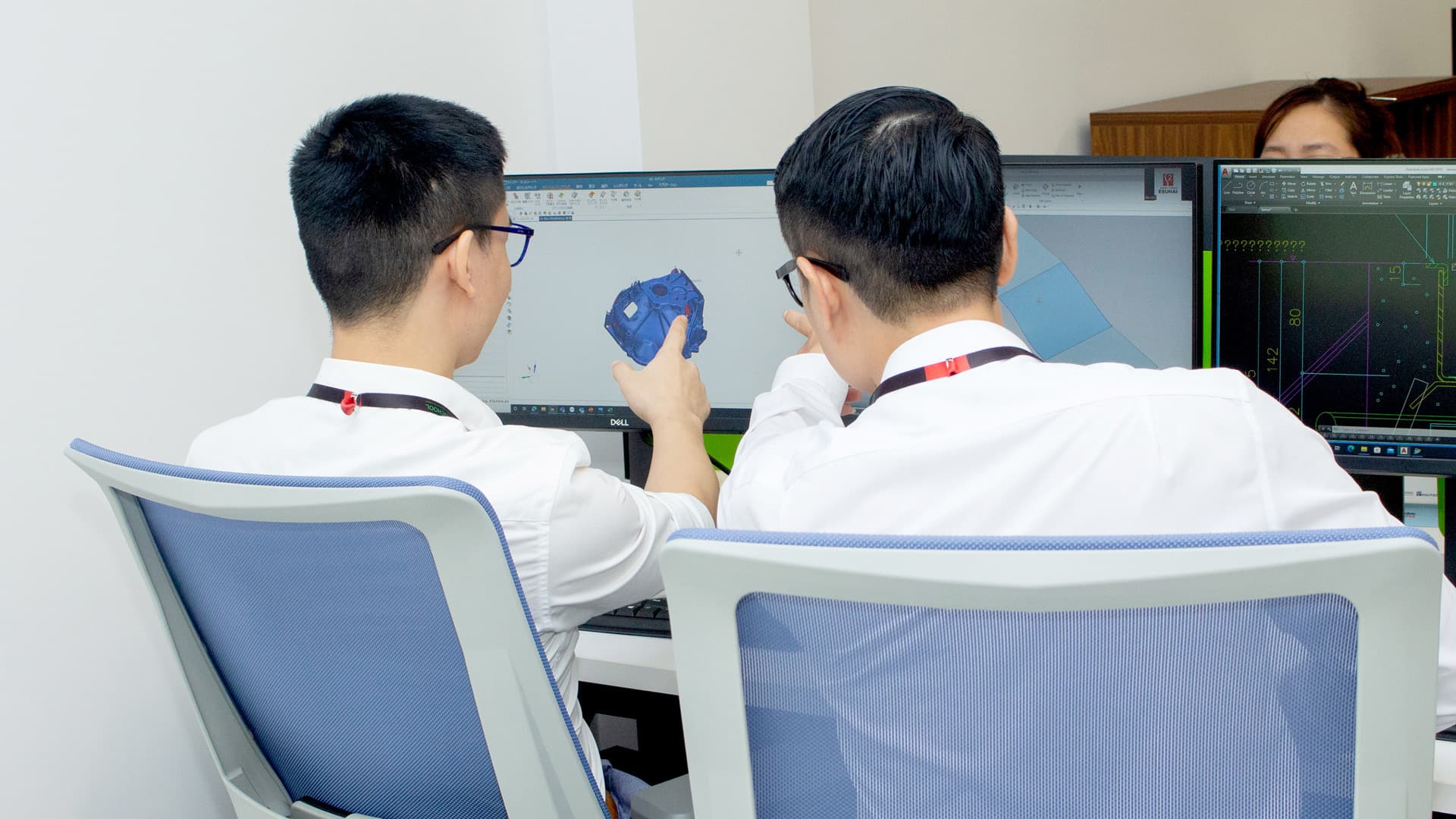 Hai kỹ sư trao đổi trên bản vẽ CAD 3D hiển thị trên màn hình