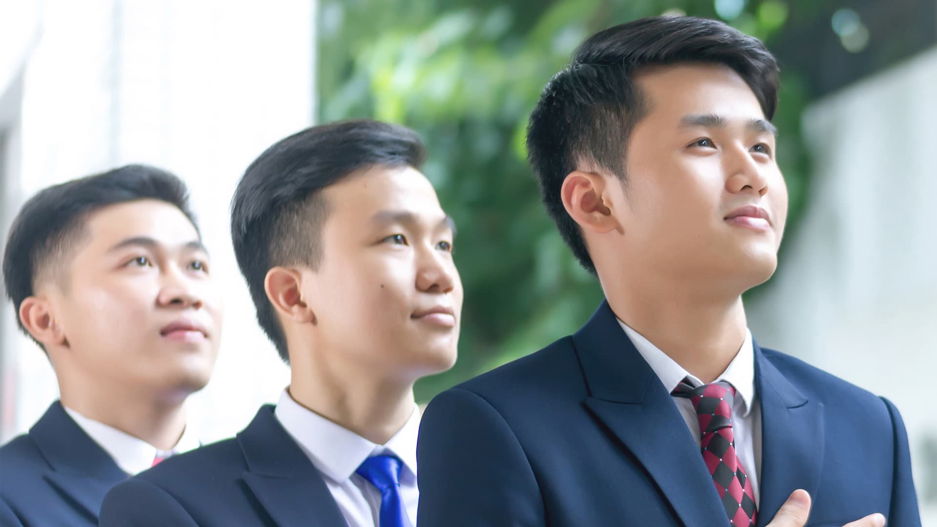 Ba người mặc vest công sở nhìn về phía trước