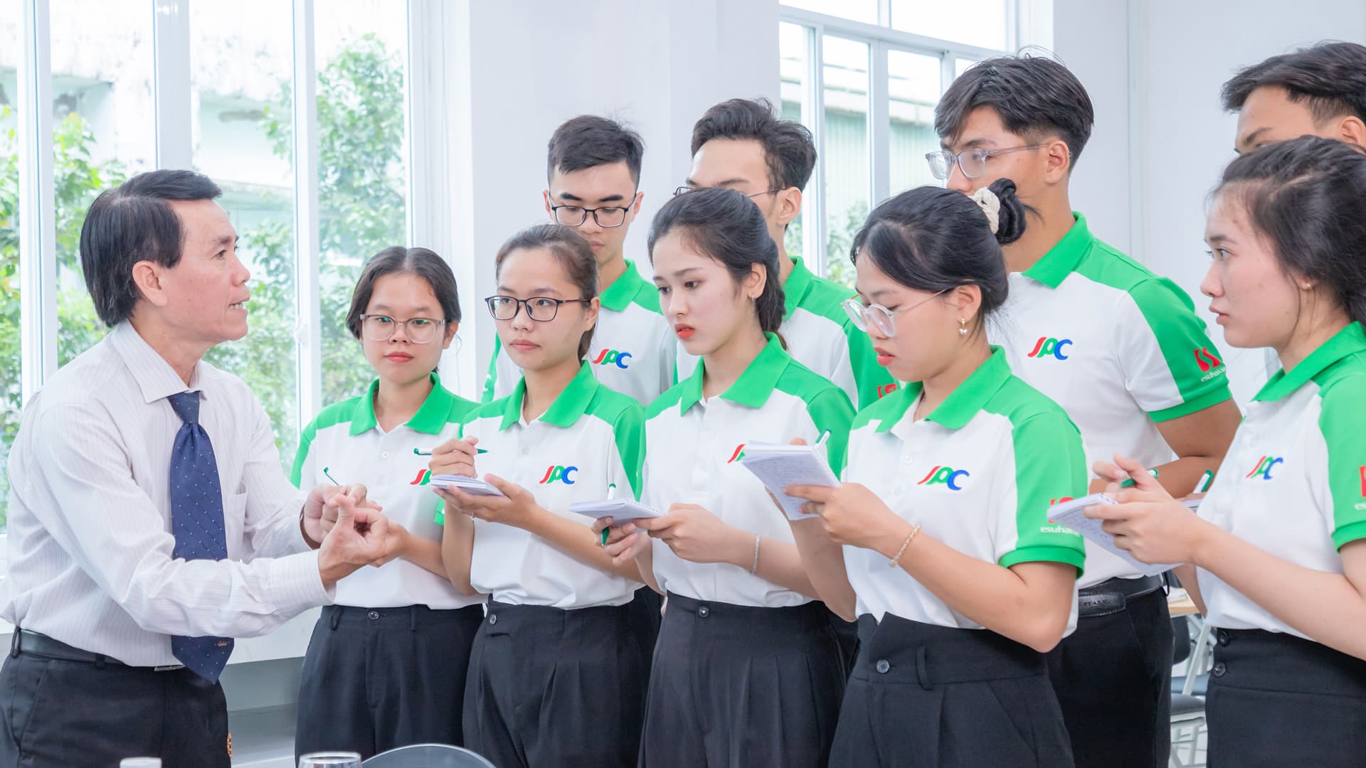 Giảng viên hướng dẫn nhóm học viên mặc đồng phục Trường JPC đang ghi chép