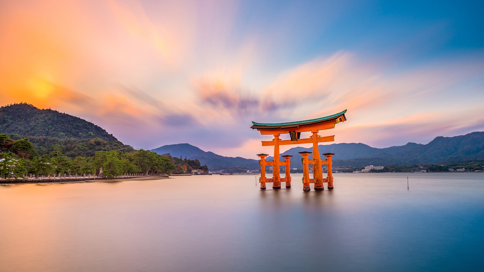 Cổng torii đỏ nổi trên mặt biển Nhật Bản lúc hoàng hôn