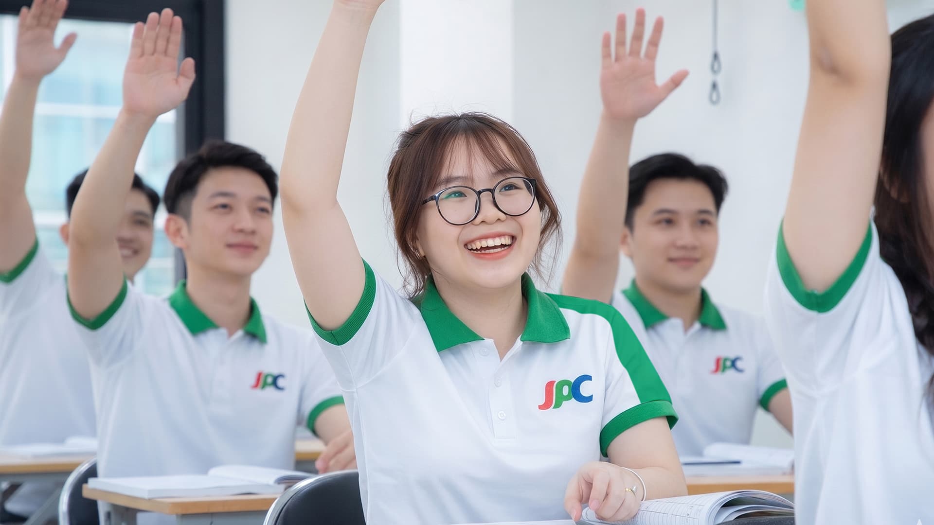Học viên mặc đồng phục Trường JPC giơ tay phát biểu trong lớp học
